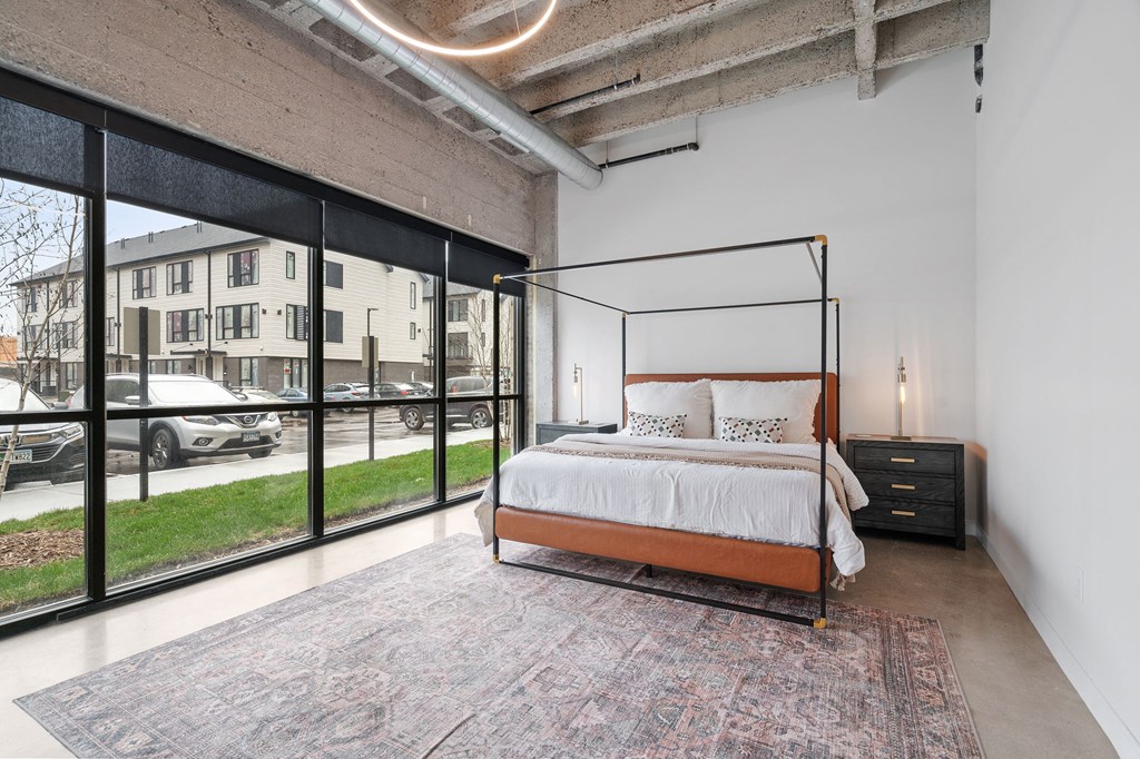 a bedroom with a bed and a large window