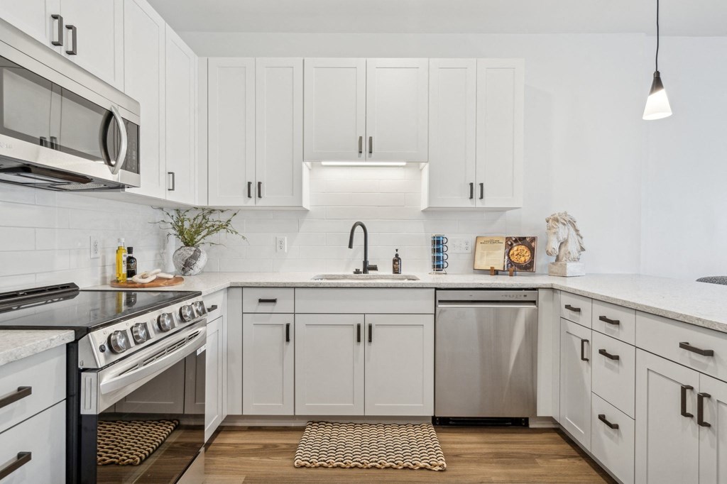 A modern kitchen with white cabinets and stainless steel appliances.