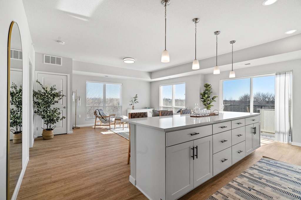 an open kitchen and living room with white cabinets and a large island