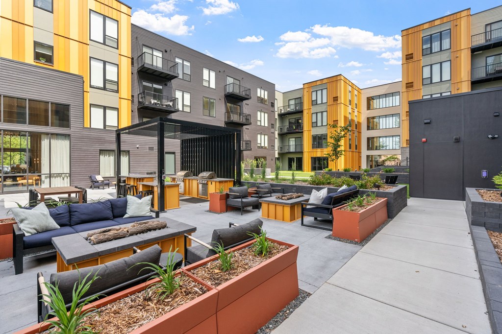 A patio area with a black table and chairs in front of a building.
