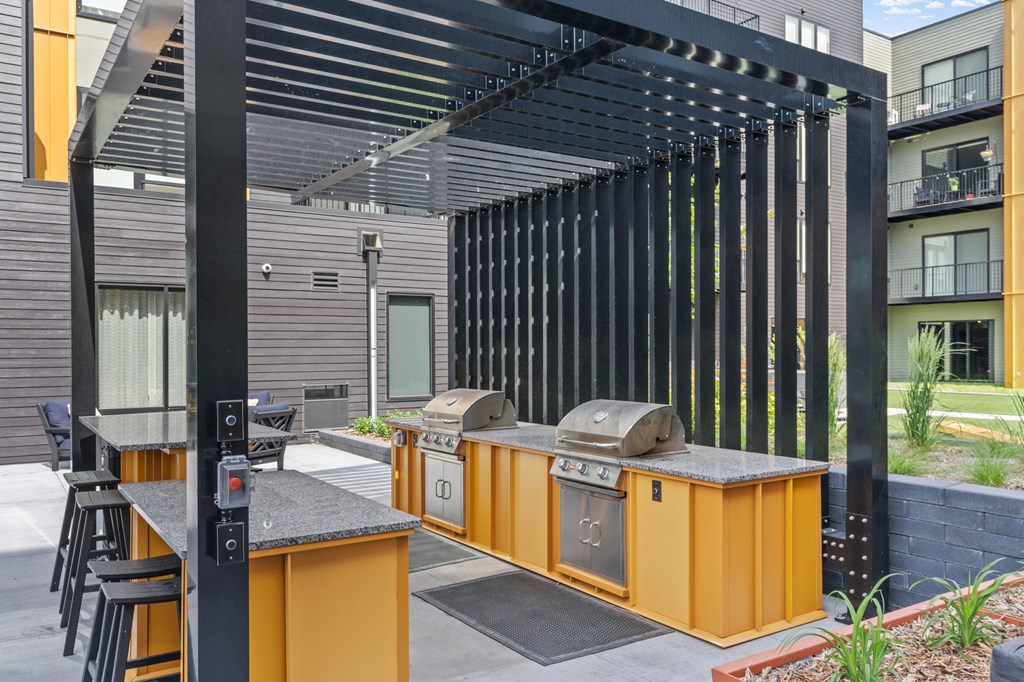 A modern outdoor kitchen with a grill and sink.