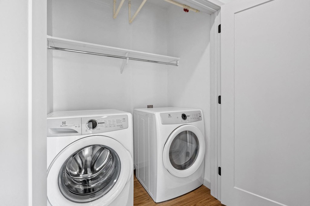 a white laundry room with a washing machine and a washer and dryer