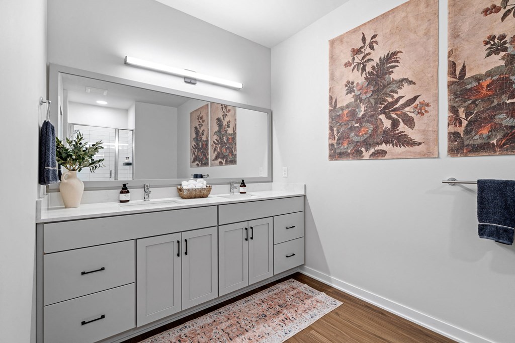 a bathroom with white cabinets and a sink and a mirror