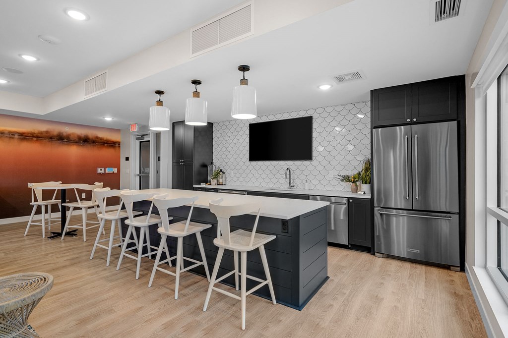 a kitchen with a table and chairs in front of a refrigerator