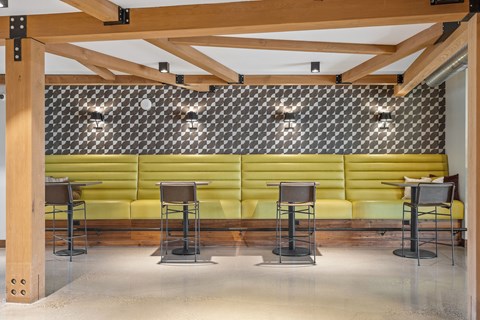 A restaurant interior with a green booth and wooden beams.