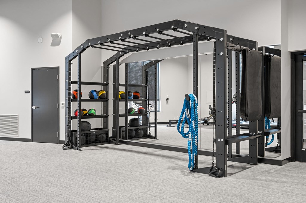 a fitness room with weights and equipment in the corner of a room