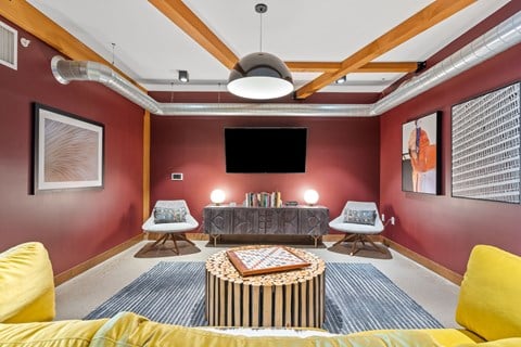 A living room with a yellow couch and a round coffee table.