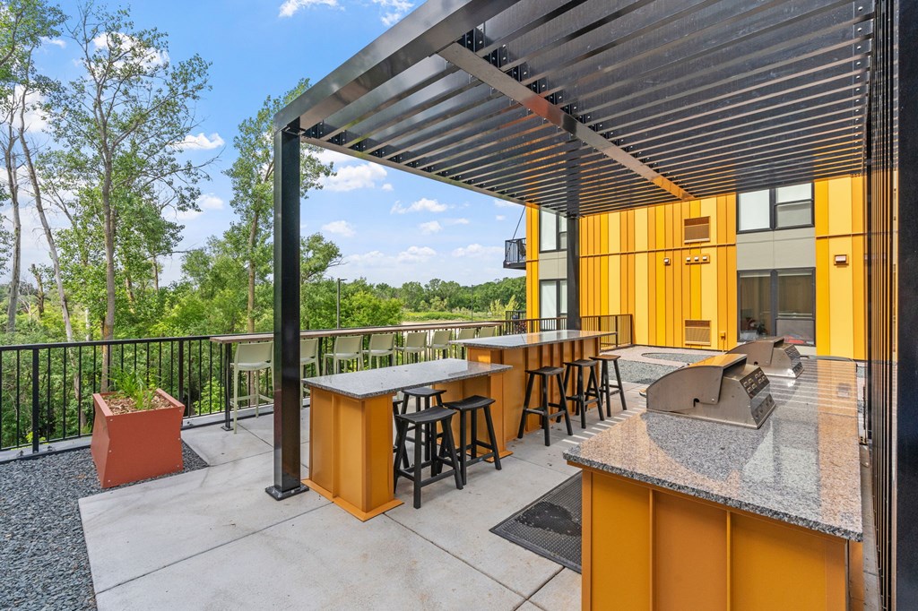 A yellow and grey outdoor bar area with a black railing.