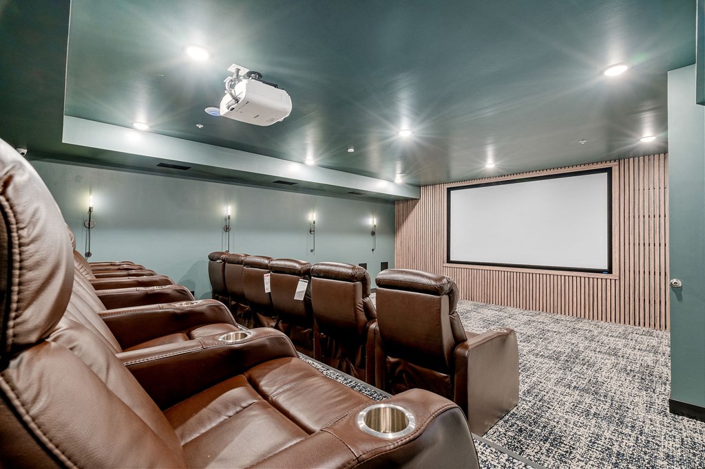 a large screening room with leather chairs and a projector screen