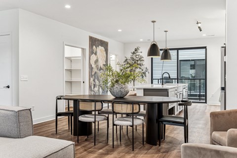 A modern dining room with a black table and chairs.