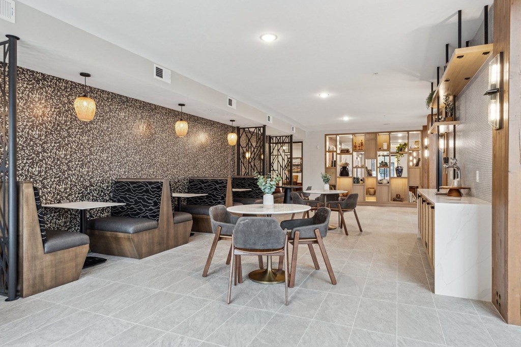 A modern dining area with a patterned wallpaper and a mix of wooden and black chairs.