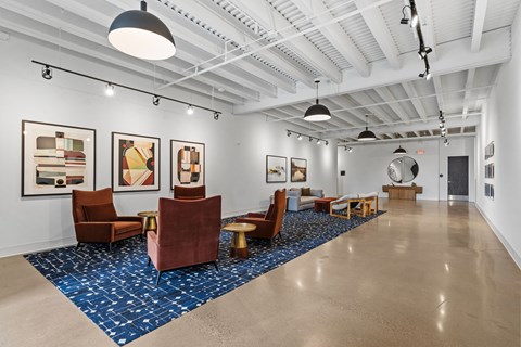 A spacious room with a blue carpet and brown chairs.