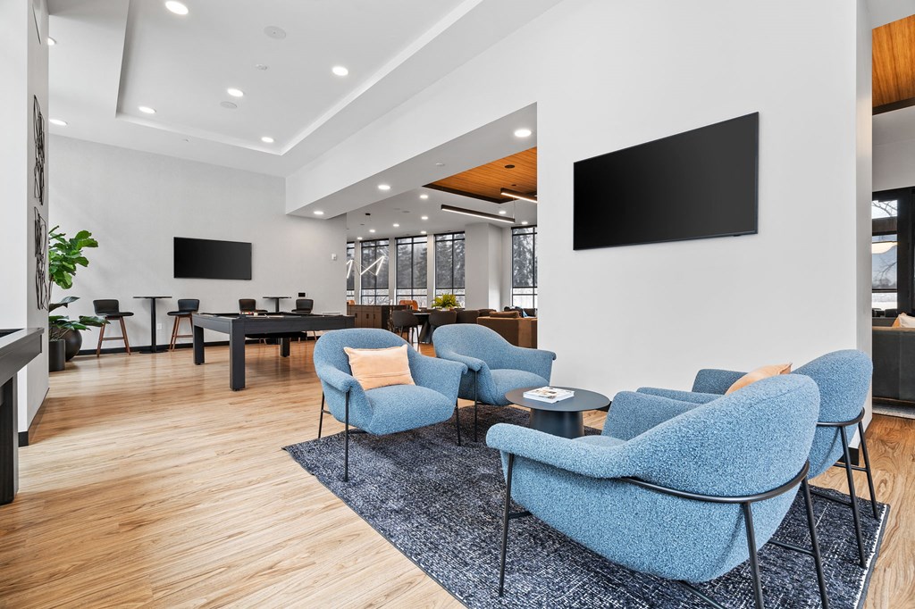 a living room with blue chairs and a tv