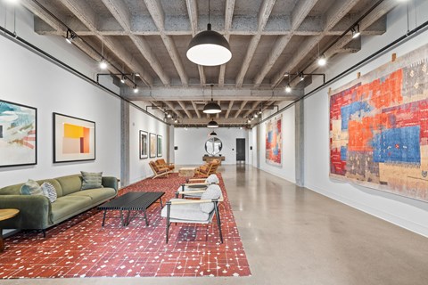 A large room with a long table and chairs and a large painting on the wall.