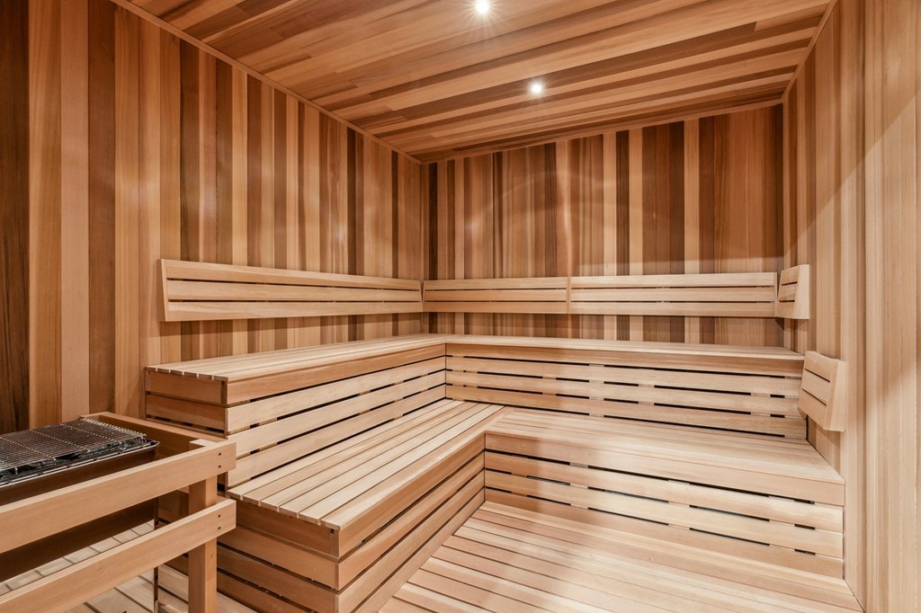 A wooden sauna with benches and a table.