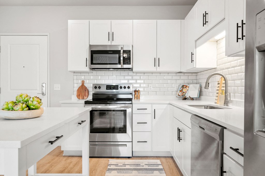 a kitchen with white cabinets and stainless steel appliances