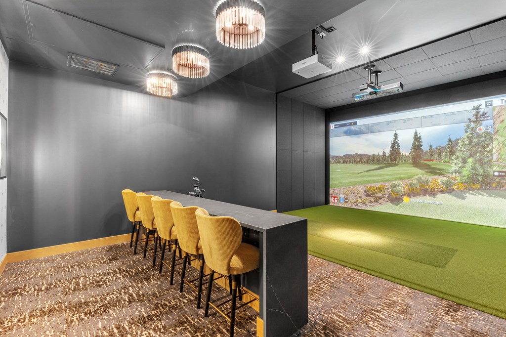A room with a long table and chairs with a screen at the end of the table.