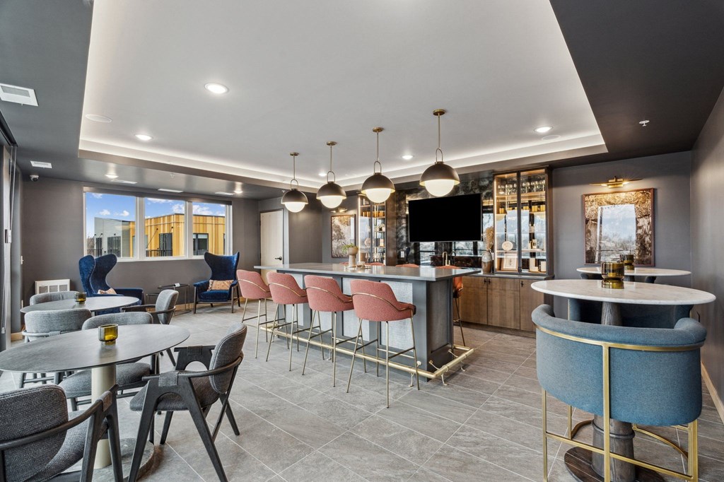 A modern dining area with a bar and chairs.