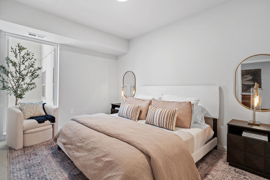 a bedroom with a bed and a chair and a window