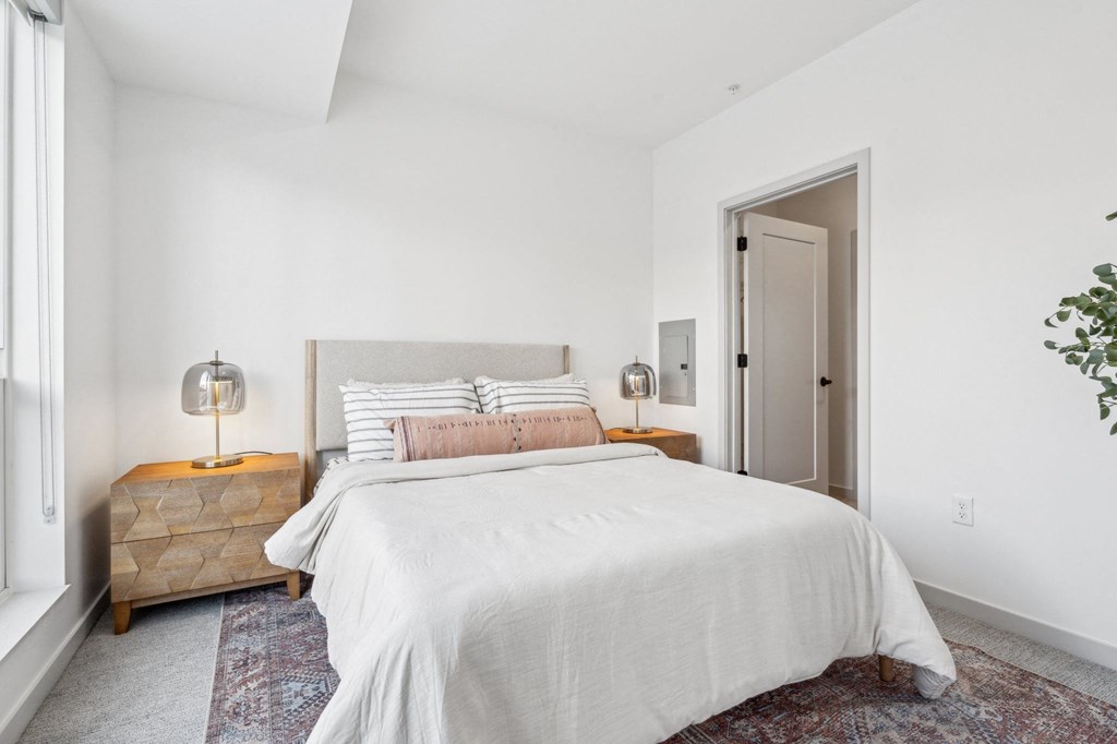 A bedroom with a large bed and a wooden chest of drawers.