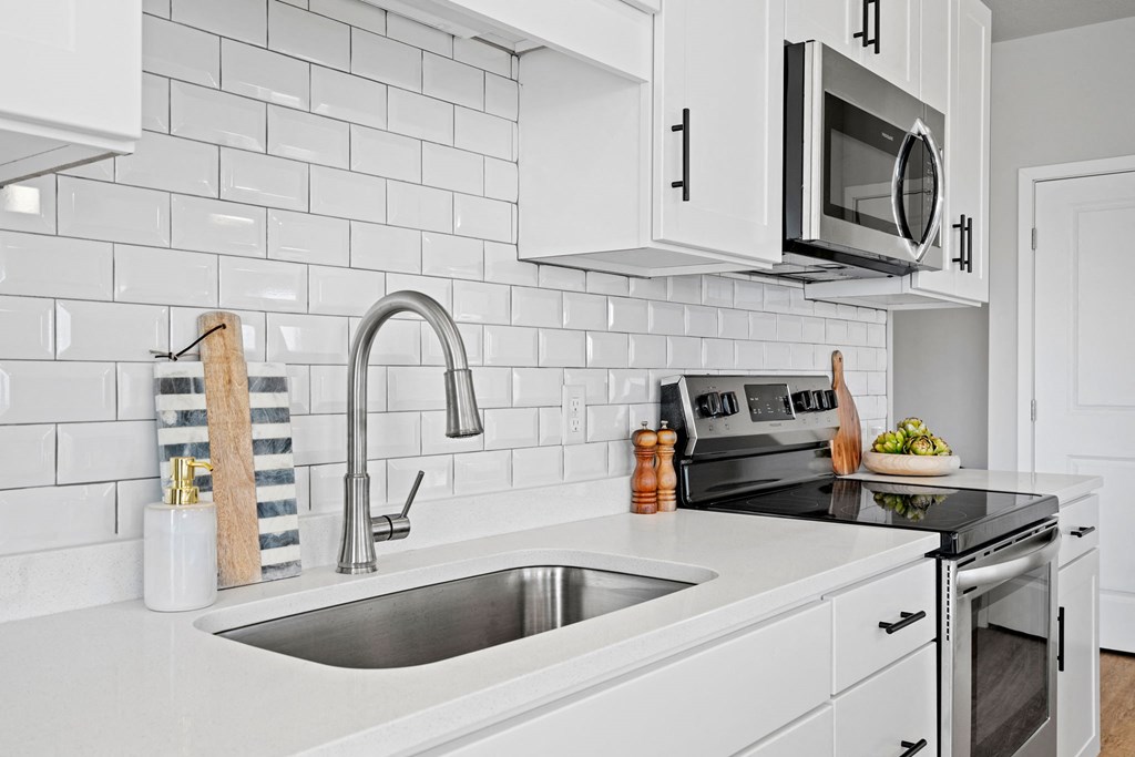 a white kitchen with a sink and a microwave