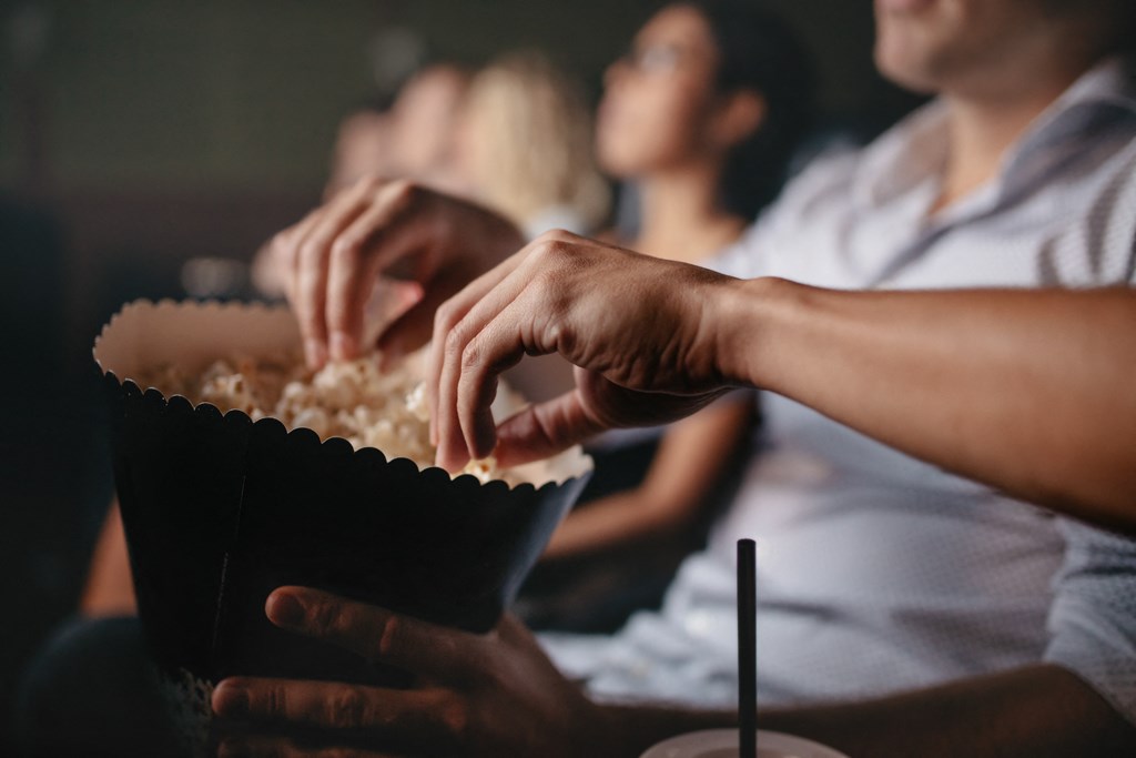 people eating popcorn in a movie theater