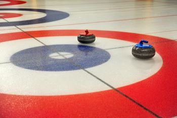 a pair of curling balls on a hockey rink