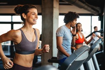 a group of people running on a treadmill in a gym