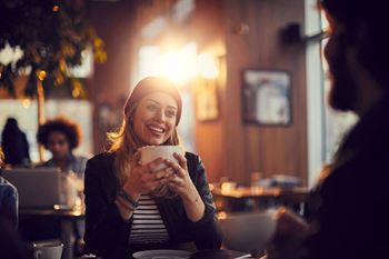 a woman drinking a cup of coffee in a restaurant