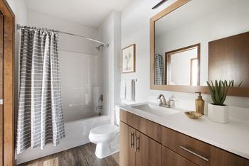 a bathroom with a toilet sink and shower and a mirror