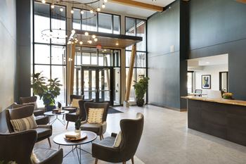 a lobby with chairs and tables and a reception desk
