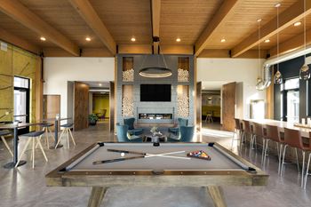 a living room with a pool table and a fireplace