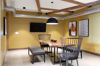 a dining room with a table and chairs and a tv