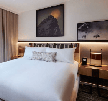 a hotel room with a white bed and a desk