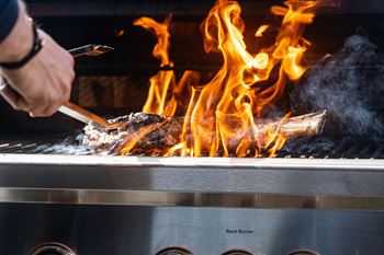 a person is cooking on a grill with fire