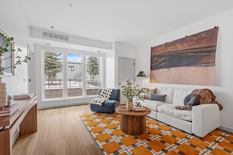 A living room with a white couch, a coffee table, and a large painting on the wall.