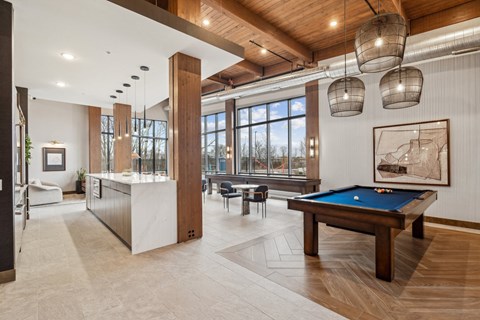 A room with a pool table and a large window.