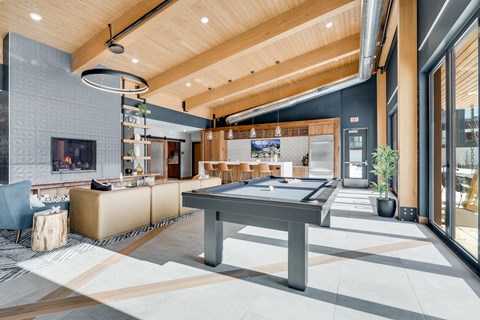 A modern living room with a pool table and a television.