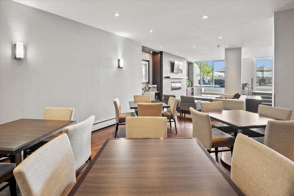 Social room with a dining room with tables and chairs at Victoria Place Apartments