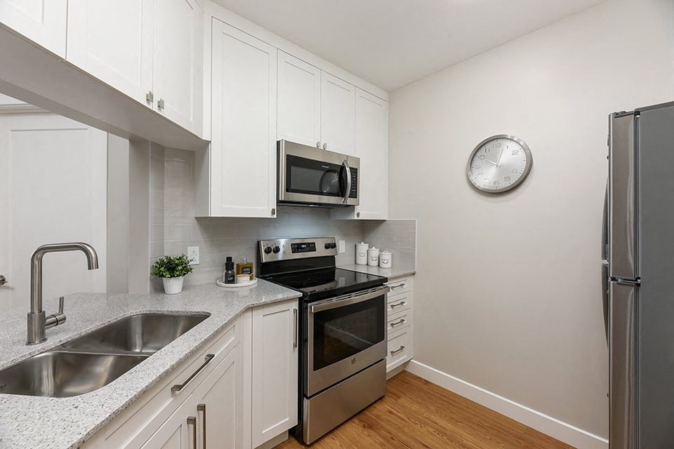 Bourg Du Village kitchen open concept kitchen with quartz countertop and stainless steel appliances in Sainte Therese, QC