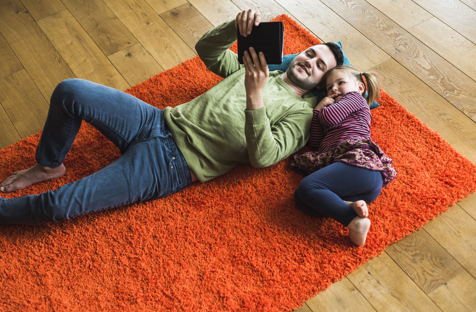Father and daughter, watching a movie on floor, inside Realstar home