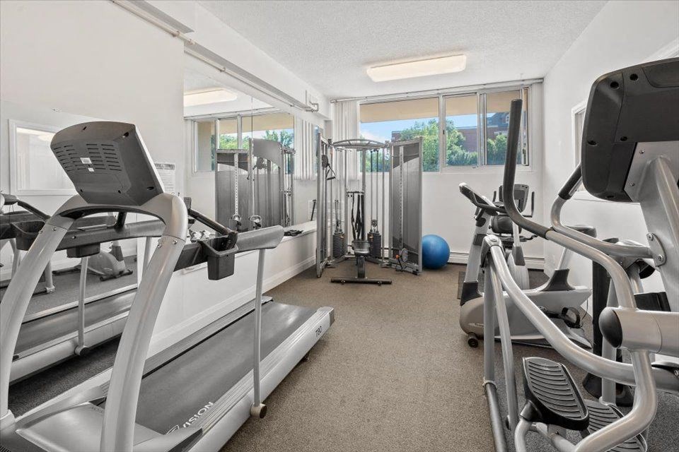 a gym with cardio equipment and weights on the floor