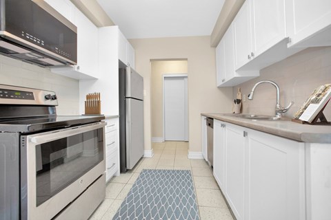 A kitchen with white cabinets and a black oven.