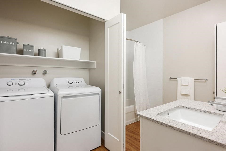 Bourg Du Village in-suite laundry with double bifold doors located in bathroom in Sainte Therese, QC