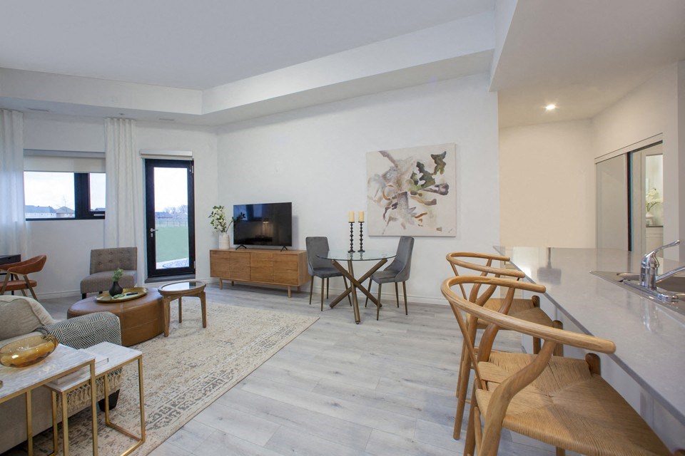 Living room and dining area, with view towards patio door at Bayfield Tower Apartments in Barrie, ON