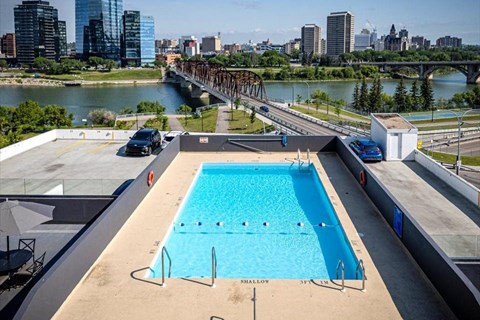 a swimming pool on the roof of a building with a city in the background