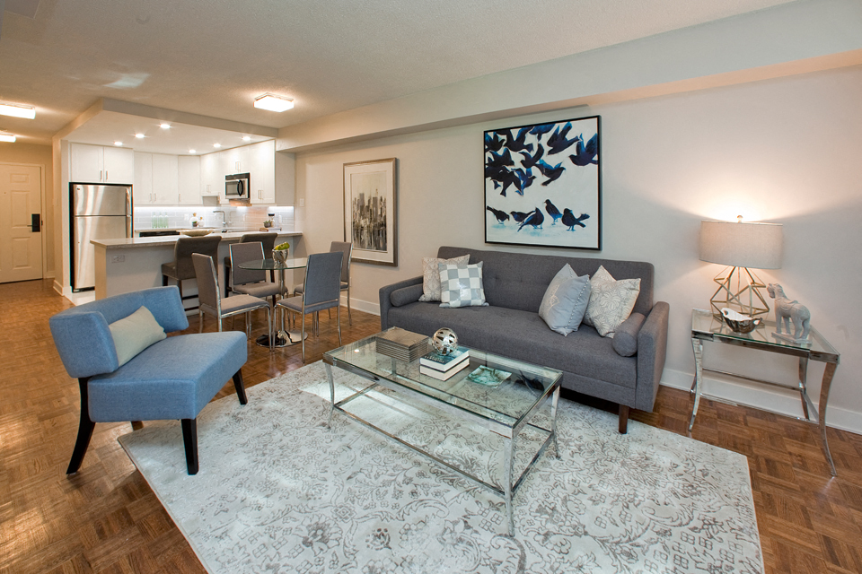 Brookbanks Elegant living room with glass coffee table and a grey couch in Toronto, ON