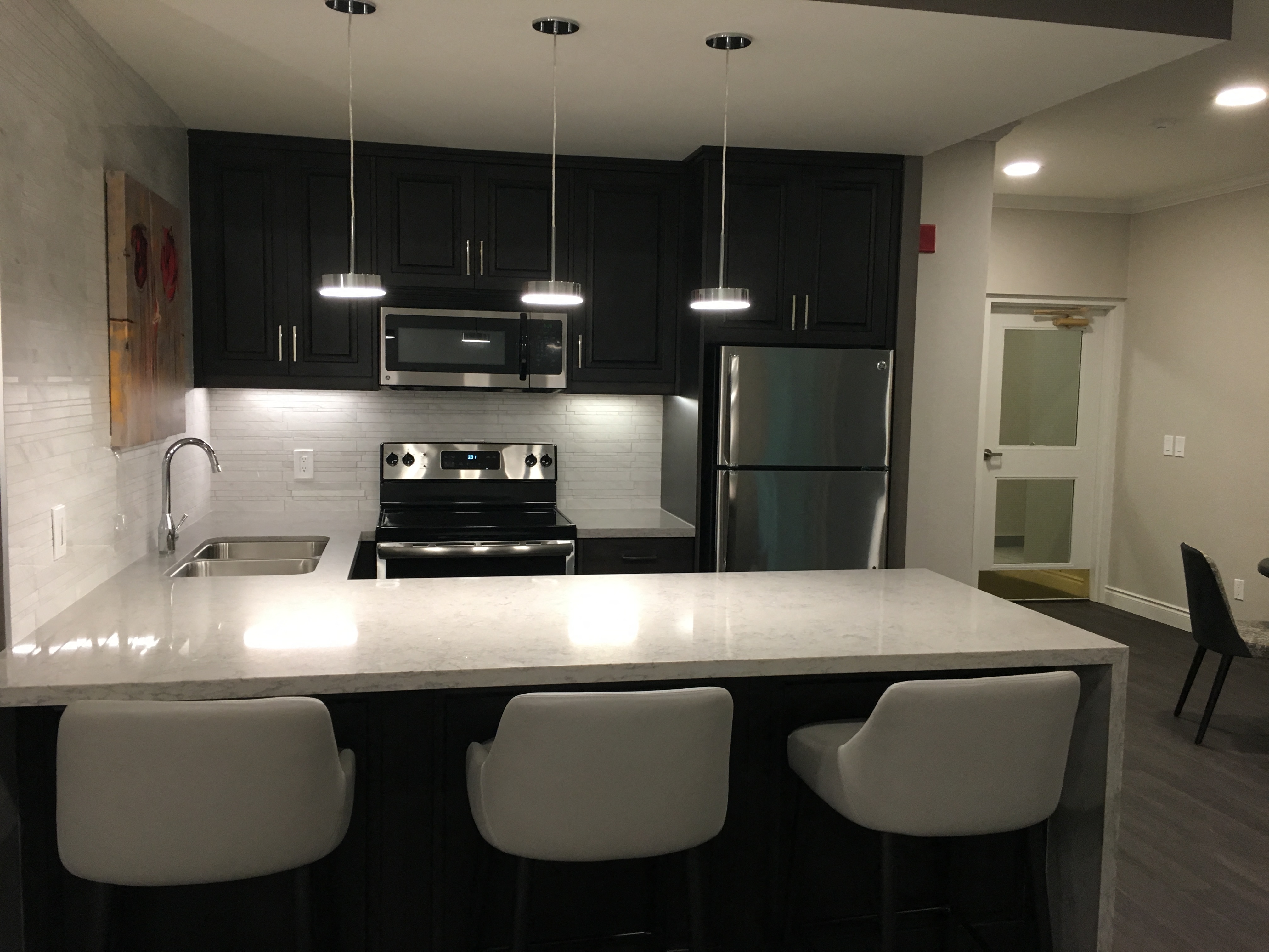 Brookbanks Kitchen in our public social room with three white chairs and a pristine white counter space in Toronto, ON