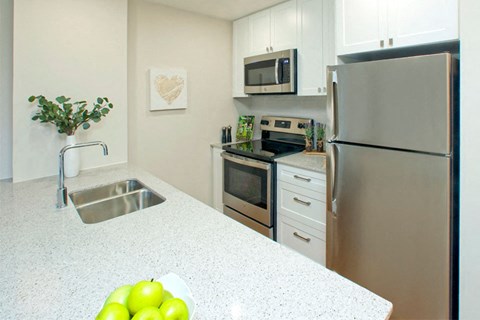 a kitchen with stainless steel appliances and white counter tops