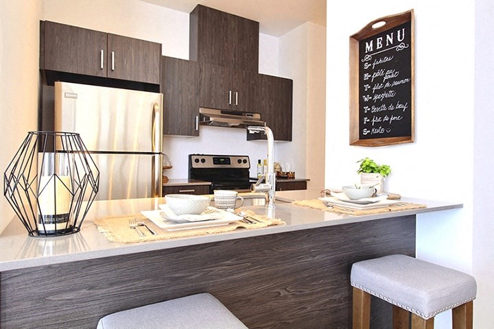 La Voile Boisbriand kitchen featuring stainless steel appliances and contemporary cabinetry in Boisbriand, QC